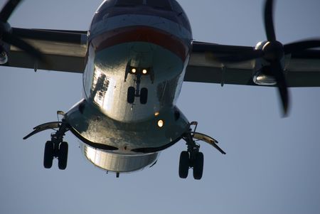 A twin-engined turboprop passenger plane landing at dusk.