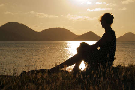 A woman watching the sunset in the Caribbean.の写真素材