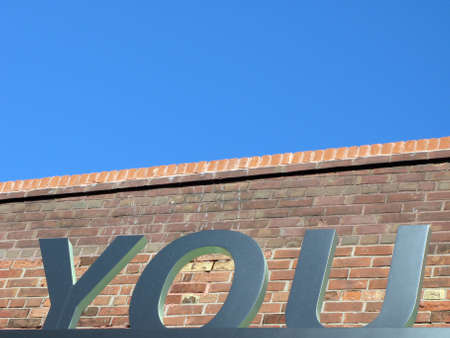 A three-dimensional metal YOU sign. The typeface is Univers.の写真素材