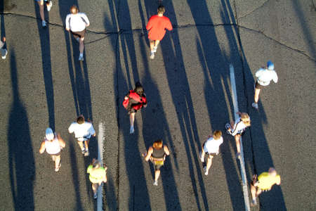 A group of marathon runners head away from the rising sun during the opening stages of a race.