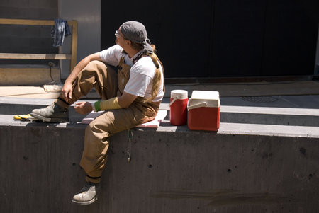 A North American construction worker takes a lunch break in the midday sun.の写真素材