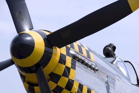 A pilot's leather flying helmet sits atop the cockpit of a P-51 Mustang fighter plane.