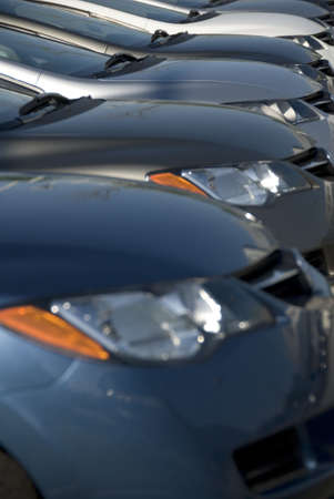 A lineup of new cars at a dealership. (Shot with minimum depth of field. Focus is on the third vehicle from the front.)の写真素材