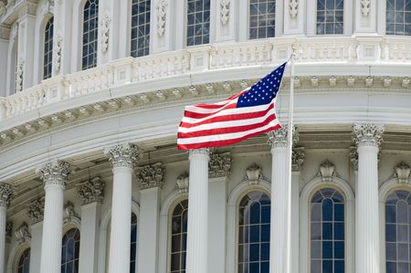 The flag of the USA flying in front of the Capitol building in Washington, DC.の写真素材