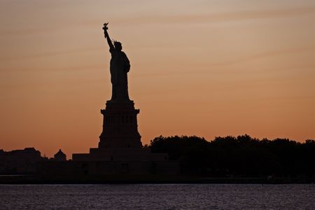 The Statue of Liberty in New York harbour at sunset.