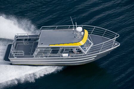 A modern water taxi shot from above while travelling fast.