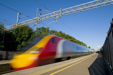 A British high speed passenger train passing through a station in the early morning.のeditorial素材