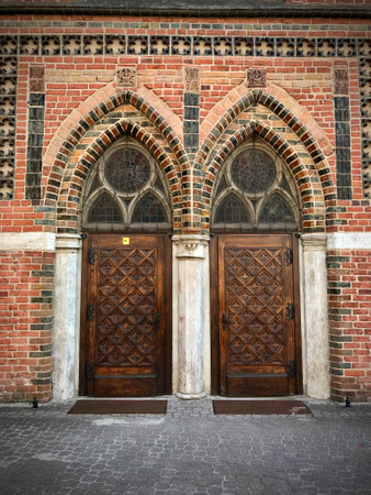Beautifully decorated historic door, brick wall.の写真素材