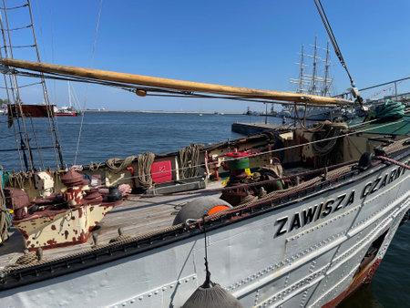 A large old sailing ship standing in the port, clearly visible sails and equipment.