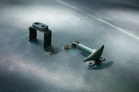 A metal bolt is sitting on a gray surface. The bolt is rusty and has a sharp pointの写真素材