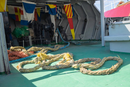 A large rope is laying on the ground in front of a building. The rope is yellow and blueの写真素材