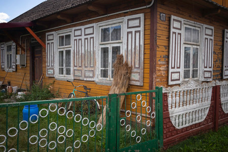 A house with a green fence and white trim. The fence has a lot of circles on itの写真素材