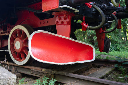 A train with a red and white wheel and a red and white piece of metal on the front
