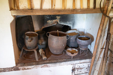 A stove with pots and pans on it. The pots are old and rusty. The stove is in a rustic settingの写真素材