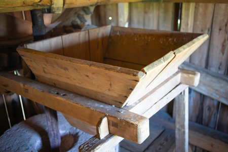 A wooden box with a wooden handle sits on a wooden table. The box is empty and the table is made of woodの写真素材