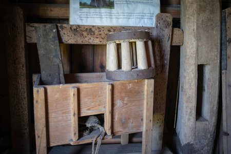 A wooden box with a hole in the middle and a rope hanging out of it. The box is old and has a rustic feel to itの写真素材