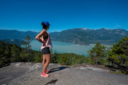 A girl takes a pause to take in a view on a hikeの写真素材