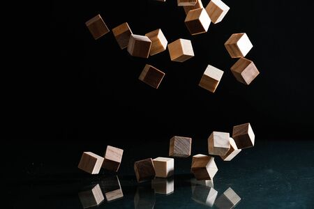 Wooden cubes flying on the black backgroundの写真素材