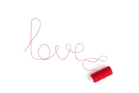 the word love laid out from a red thread with a coilの写真素材