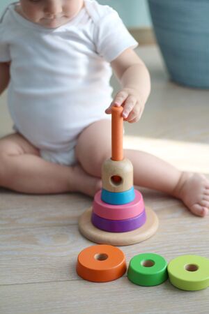 a small child sitting on the floor collects pyramidの写真素材