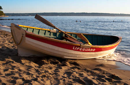 Empty lifeguard rowboat on beach at sunsetの写真素材