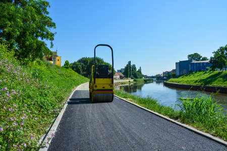 The roller aligns the new asphalt