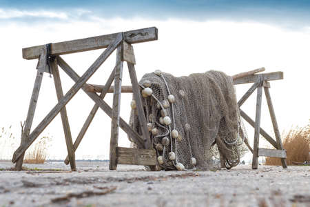 Old fishing nets are drying beside the lake on the cold weather. Blue sky in the bacground.の写真素材