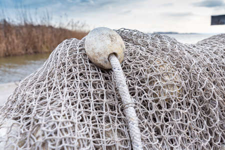 Old fishing nets are drying beside the lake on the cold weather. Blue sky in the bacground.の写真素材
