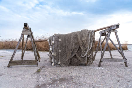 Old fishing nets are drying beside the lake on the cold weather. Blue sky in the bacground.の写真素材