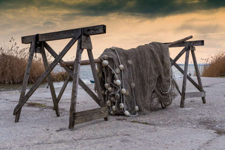 Old fishing nets are drying beside the lake on the cold weather. Blue sky in the bacground.の写真素材