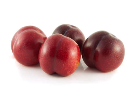 Isolated red ripe plums on a white background. Fresh diet fruit. Healthy fruit with vitamins.の写真素材