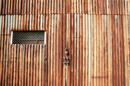 Background: pattern of rusty grunge zinc door with master key lock 