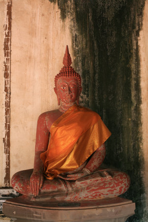 Ornament: red ancient buddha statue with grunge wallのeditorial素材