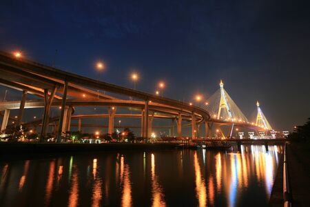 Background  night landscape of Bhumibol, aka Industrial Ring road, bridge and reservoir near Chao Phraya river in Bangkok, Thailand の写真素材