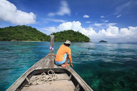 Travel background  sea sailor on wooden boat waiting visitors snorkeling to see coral reef on transparent andaman sea at Surin islands national park, Thailandの写真素材