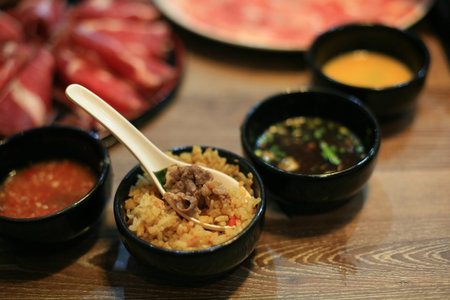 Food background  shabu beef and garlic fried rice on the black bowl with dipping source on the table...