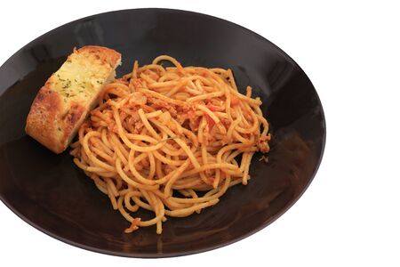 Italian food   fresh spaghetti with tomato sauce and pork serving with garlic bread isolated on whiteの写真素材
