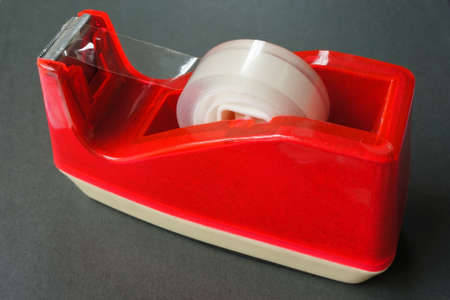 Sticky, scotch, tape on red holder isolated on blackの写真素材