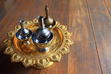 Silver pour water containers on golden tray for Buddhist libation