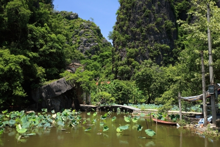Lotus pond and pedestrian bridge entrance to visit Bich Dong pagoda in Ninh Binh, Vietnamの写真素材
