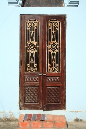 Vintage brown door with gold wrought iron gratingの写真素材