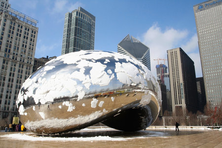 CHICAGO,IL-FEB 09  Skygate Bean covering by snow against high building towers and blue sky with unidentified visitors at Millenium Park on February 09, 2008 in Chicago, IL USA のeditorial素材