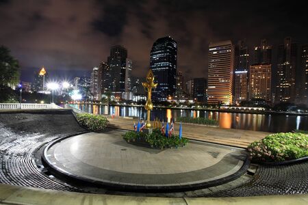 Golden lotus statue at Benjakitti park against modern buildings in Bangkok, Thailandの写真素材