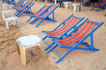 Deck chairs with plastic tables on the beach at Pattaya, Thailand の写真素材