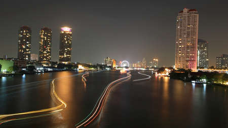 Light trails on Chao Phraya River at night in Bangkok, Thailandの写真素材