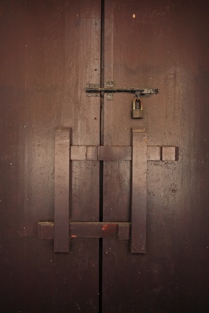 Antique wooden door locked by key and timber  の写真素材