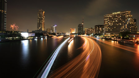 BANGKOK-DEC 05  Cityscape of light trails on Chao Phraya River and firework in Bangkok, Thailand on December 05, 2012  Boat can transfer to historic, and business spots around Bangkok by 9 piers  のeditorial素材