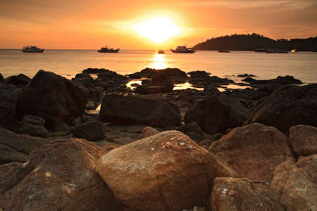 Sunset over the sea with beautiful rocks on the bayの写真素材