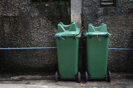 Two green trash in front of grunge wallの写真素材