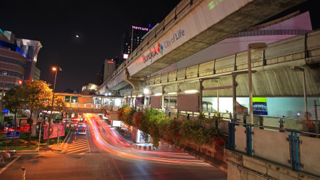 BANGKOK-MAR 16 Light trail on Rama I street with public sky walk at Pathumwan junction on March 16, 2013 in Bangkok, Thailand  Sky walk can link to BTS sky train station named National stadium のeditorial素材